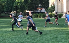 Students playing ultimate frisbee on the Cathedral lawn